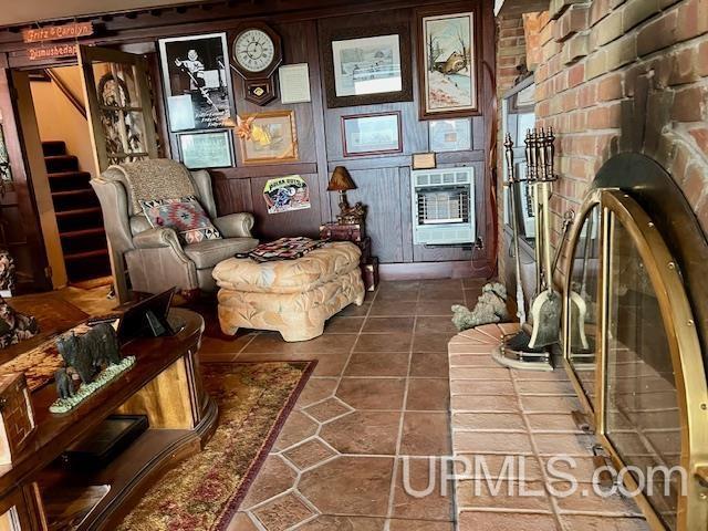 9411 Goodell Rd, Eagle Harbor, MI 49950 - living area featuring heating unit, tile patterned flooring, and stairs