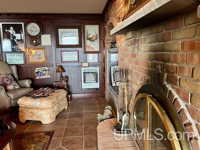 9411 Goodell Rd, Eagle Harbor, MI 49950 - living room with dark tile patterned floors, heating unit, and brick wall