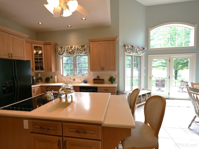 52765 Bootjack Rd, Lake Linden, MI 49945 - kitchen featuring a sink, black appliances, light countertops, a center island with sink, and light tile patterned flooring