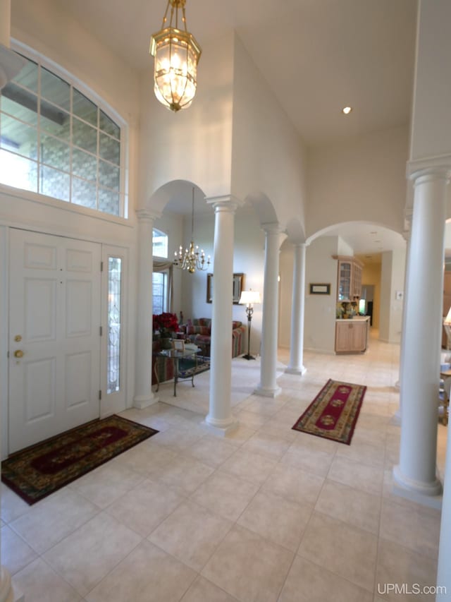 52765 Bootjack Rd, Lake Linden, MI 49945 - entryway featuring a high ceiling, a chandelier, arched walkways, ornate columns, and light tile patterned floors