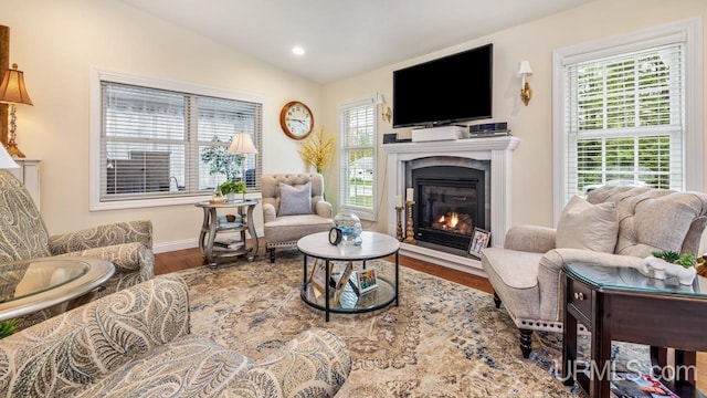 6376 Marie L.45 Ln, Escanaba, MI 49829 - living room featuring wood finished floors, a glass covered fireplace, lofted ceiling, baseboards, and recessed lighting