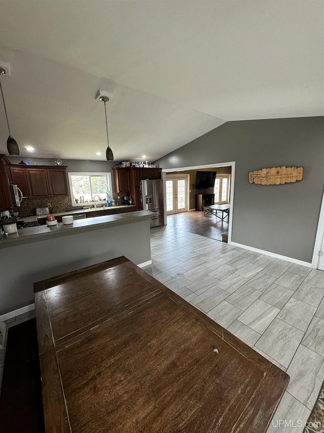 59 Forest Dr, Negaunee, MI 49866 - kitchen featuring appliances with stainless steel finishes, baseboards, lofted ceiling, tasteful backsplash, and a peninsula
