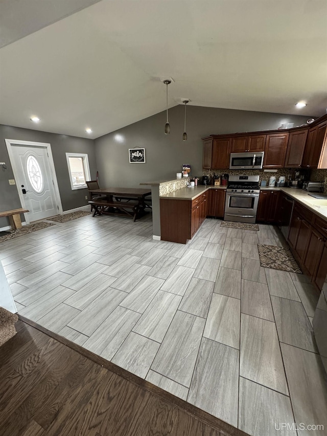 59 Forest Dr, Negaunee, MI 49866 - kitchen with stainless steel appliances, a peninsula, lofted ceiling, wood finish floors, and light countertops