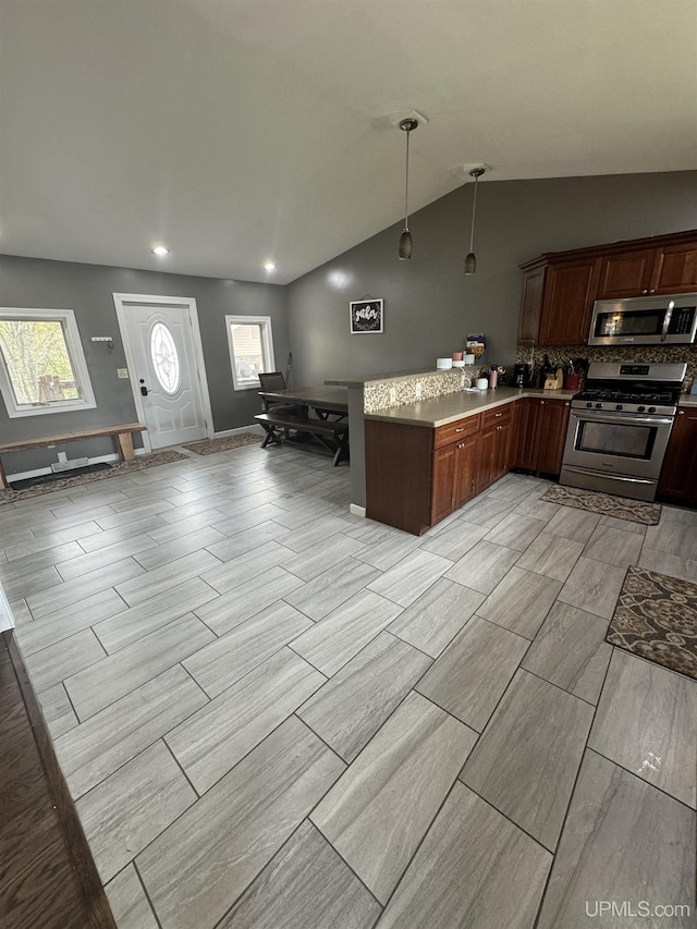 59 Forest Dr, Negaunee, MI 49866 - kitchen with stainless steel appliances, a peninsula, vaulted ceiling, plenty of natural light, and hanging light fixtures