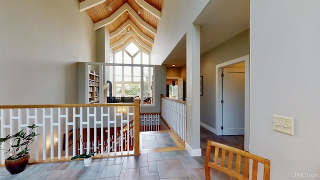 N9910 Shore Dr, Au Train, MI 49806 - hallway with stone tile flooring, an upstairs landing, a towering ceiling, and baseboards