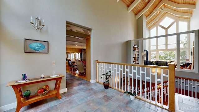 N9910 Shore Dr, Au Train, MI 49806 - corridor featuring stone finish flooring, baseboards, a high ceiling, and wooden ceiling with exposed beams