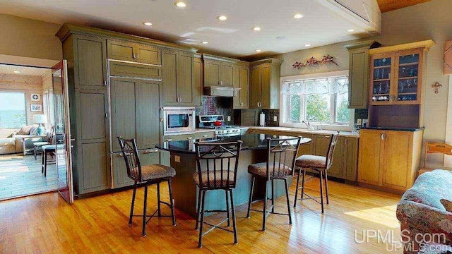 N9910 Shore Dr, Au Train, MI 49806 - kitchen with built in appliances, exhaust hood, light wood-style floors, a kitchen breakfast bar, and recessed lighting