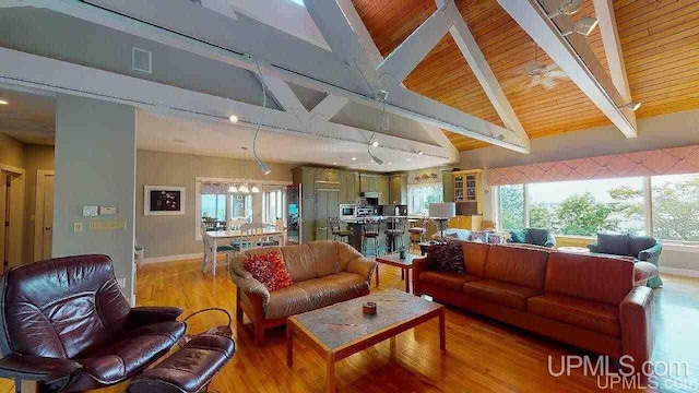 N9910 Shore Dr, Au Train, MI 49806 - living room featuring light wood-style floors, a chandelier, wood ceiling, plenty of natural light, and baseboards