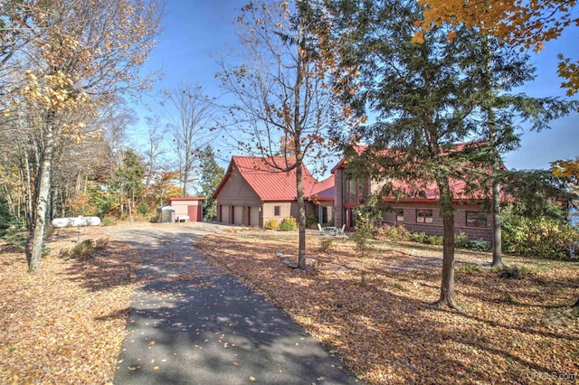 N9910 Shore Dr, Au Train, MI 49806 - view of front of home featuring driveway, an attached garage, and metal roof