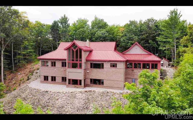 N9910 Shore Dr, Au Train, MI 49806 - rear view of house with a standing seam roof, metal roof, and stairway