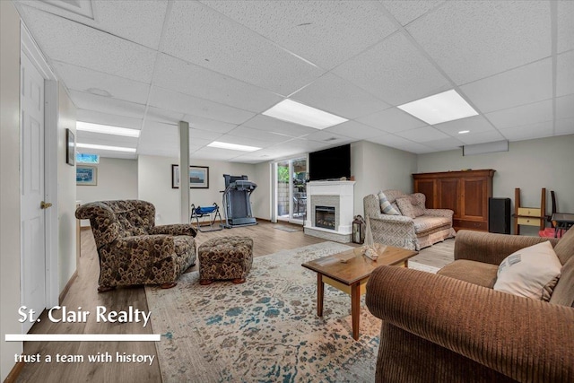 1080 Highland Dr, Saint Clair, MI 48079 - living area featuring wood finished floors, a paneled ceiling, a glass covered fireplace, and baseboards
