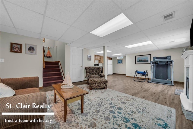 1080 Highland Dr, Saint Clair, MI 48079 - living room with wood finished floors, stairs, a drop ceiling, and baseboards