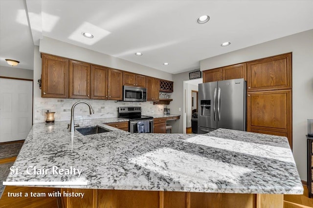 1080 Highland Dr, Saint Clair, MI 48079 - kitchen with stainless steel appliances, a sink, a peninsula, light stone countertops, and tasteful backsplash