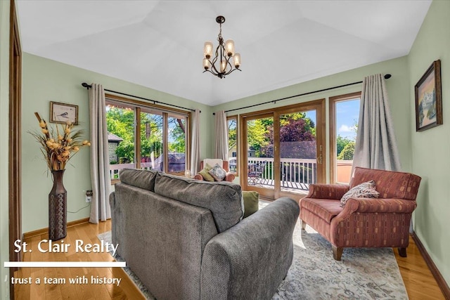 1080 Highland Dr, Saint Clair, MI 48079 - living room featuring light wood-style floors, a chandelier, vaulted ceiling, and baseboards