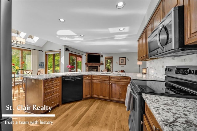 1080 Highland Dr, Saint Clair, MI 48079 - kitchen featuring appliances with stainless steel finishes, a skylight, brown cabinetry, light wood finished floors, and recessed lighting