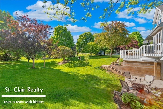1080 Highland Dr, Saint Clair, MI 48079 - view of grassy yard featuring a fire pit, a wooden deck, and a patio area