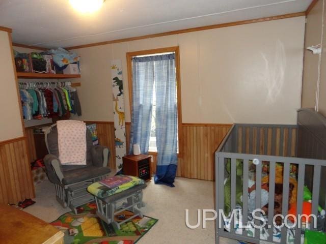 2801 M-94 Hwy, Eben Junction, MI 49825 - bedroom featuring a wainscoted wall, ornamental molding, carpet flooring, wood walls, and a closet