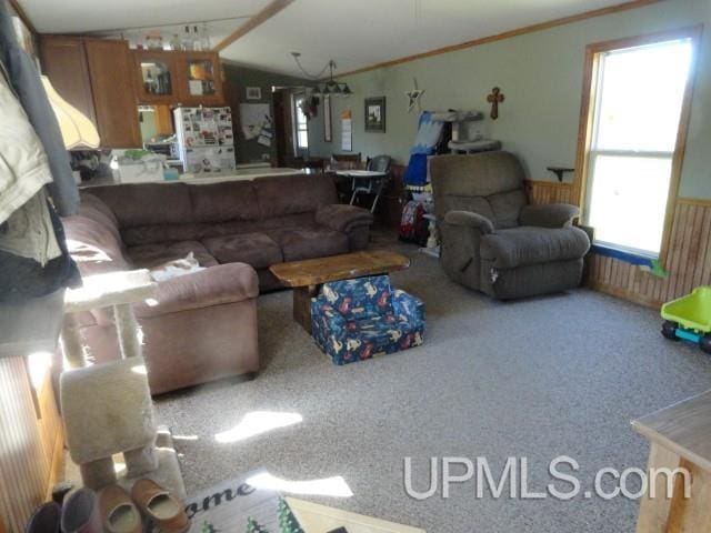 2801 M-94 Hwy, Eben Junction, MI 49825 - living area featuring plenty of natural light, lofted ceiling, carpet, a wainscoted wall, and crown molding