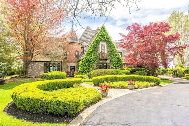 49016 Pointe Lakeview Dr, Chesterfield, MI 48047 - tudor-style house with stone siding and a chimney
