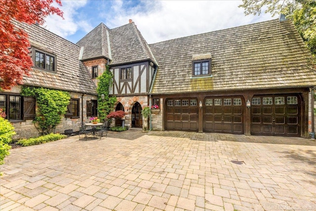 49016 Pointe Lakeview Dr, Chesterfield, MI 48047 - english style home featuring stone siding, decorative driveway, and a garage