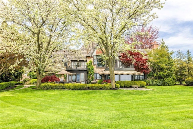 49016 Pointe Lakeview Dr, Chesterfield, MI 48047 - tudor-style house with a front yard, a balcony, and a chimney