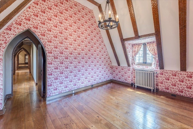 49016 Pointe Lakeview Dr, Chesterfield, MI 48047 - spare room with radiator, wallpapered walls, a chandelier, wood-type flooring, and arched walkways