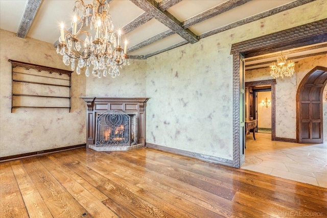 49016 Pointe Lakeview Dr, Chesterfield, MI 48047 - unfurnished living room with a chandelier, beam ceiling, arched walkways, a warm lit fireplace, and hardwood / wood-style flooring