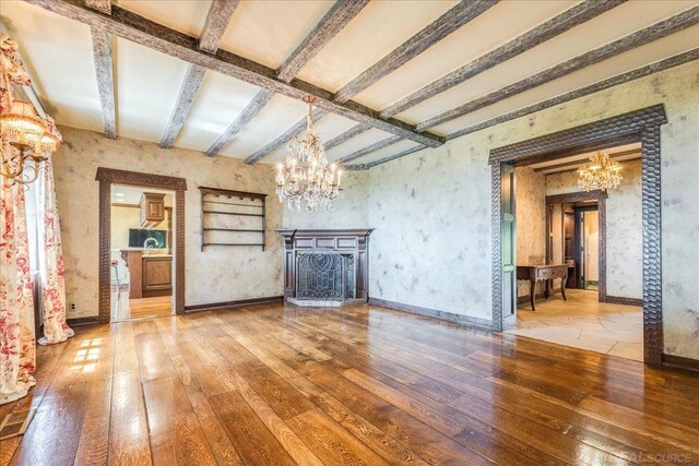 49016 Pointe Lakeview Dr, Chesterfield, MI 48047 - unfurnished living room featuring a chandelier, hardwood / wood-style flooring, beam ceiling, wallpapered walls, and a fireplace