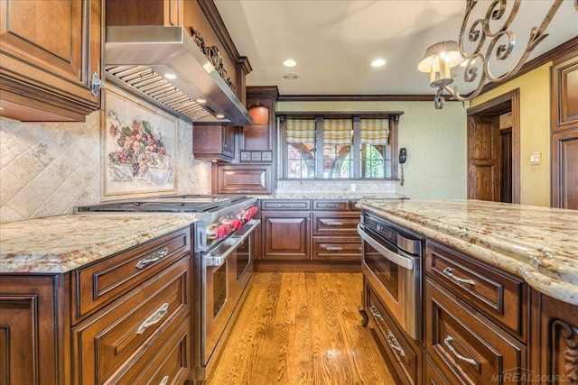 49016 Pointe Lakeview Dr, Chesterfield, MI 48047 - kitchen with double oven range, range hood, light stone countertops, backsplash, and crown molding