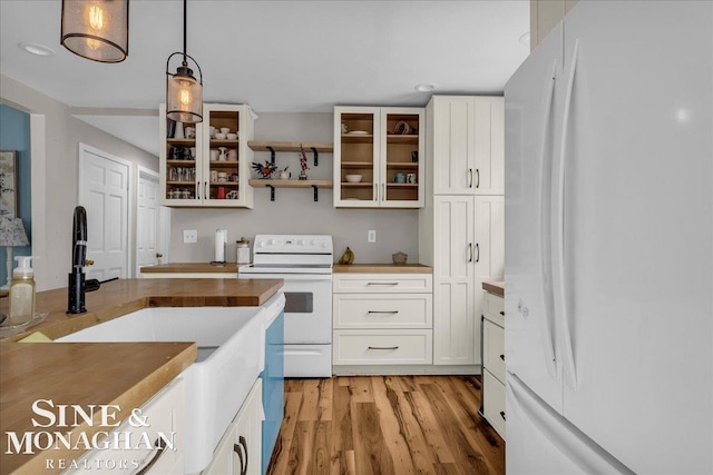 1923 Clinton Ave, Saint Clair, MI 48079 - kitchen with white appliances, white cabinets, light wood-type flooring, hanging light fixtures, and recessed lighting