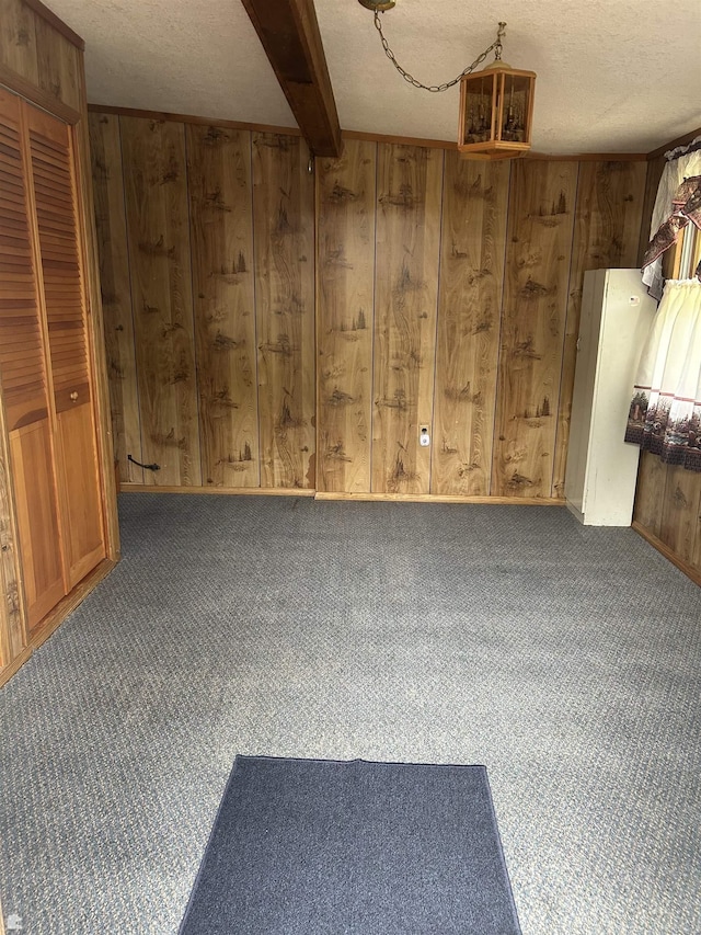 1923 Bear Dr, Oscoda, MI 48750 - unfurnished room featuring wooden walls, carpet, and beamed ceiling