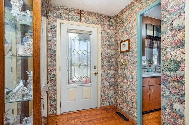 5149 Reinhardt Ln, Bay City, MI 48706 - foyer entrance featuring wallpapered walls, light wood-type flooring, and baseboards