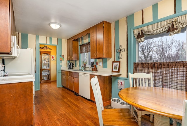 5149 Reinhardt Ln, Bay City, MI 48706 - kitchen with white appliances, wallpapered walls, a sink, wood finished floors, and brown cabinets