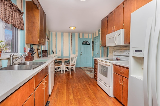 5149 Reinhardt Ln, Bay City, MI 48706 - kitchen with white appliances, wallpapered walls, a sink, light wood-style floors, and light countertops