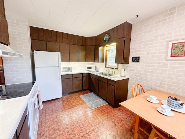 812 Spruce St, Marquette, MI 49855 - kitchen with white appliances, a sink, light countertops, light floors, and brick wall