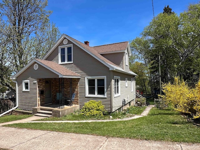 812 Spruce St, Marquette, MI 49855 - bungalow-style house with a chimney, covered porch, roof with shingles, and a front yard