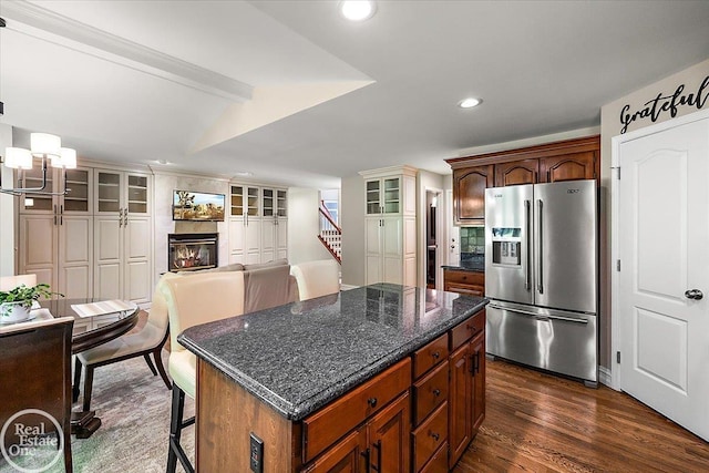 63011 Indian Hills Dr Unit # 1, Washington Twp, MI 48095 - kitchen with stainless steel fridge with ice dispenser, dark wood finished floors, a glass covered fireplace, a chandelier, and a center island