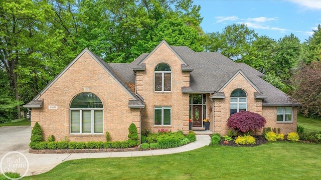 63011 Indian Hills Dr Unit # 1, Washington Twp, MI 48095 - view of front of house featuring brick siding, a front yard, and a shingled roof