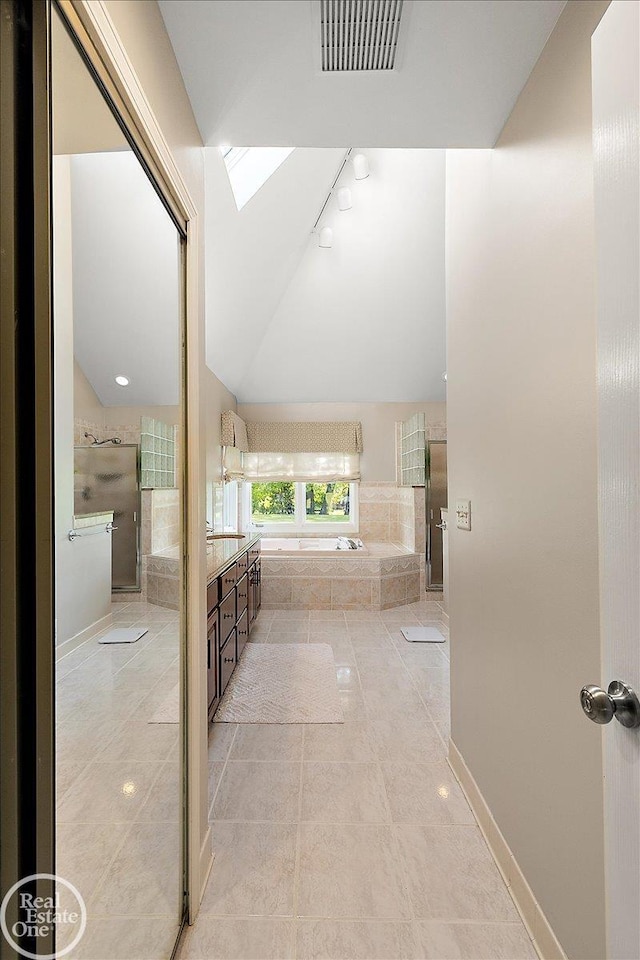 63011 Indian Hills Dr Unit # 1, Washington Twp, MI 48095 - full bath with a skylight, tile patterned flooring, vanity, a garden tub, and lofted ceiling
