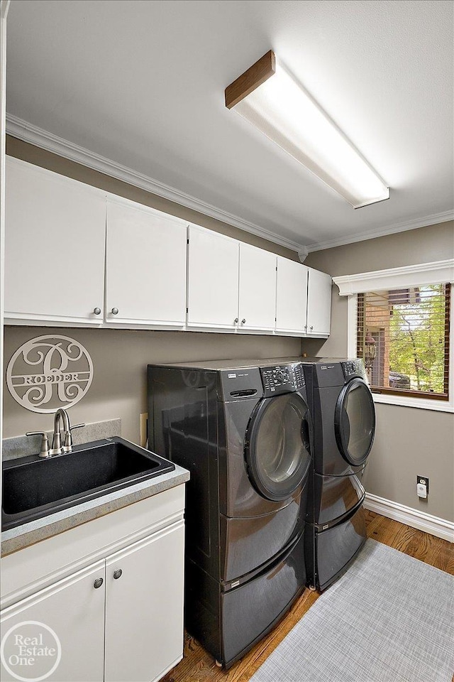 63011 Indian Hills Dr Unit # 1, Washington Twp, MI 48095 - laundry area with cabinet space, separate washer and dryer, baseboards, crown molding, and wood finished floors