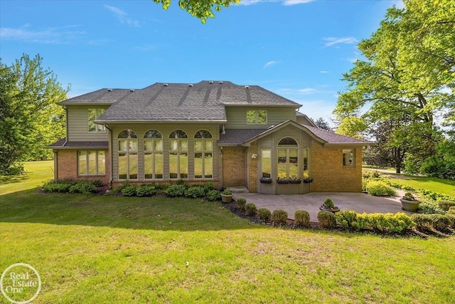 63011 Indian Hills Dr Unit # 1, Washington Twp, MI 48095 - back of property with brick siding, a yard, a shingled roof, and a patio area