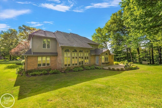 63011 Indian Hills Dr Unit # 1, Washington Twp, MI 48095 - rear view of house with a patio area, brick siding, and a yard