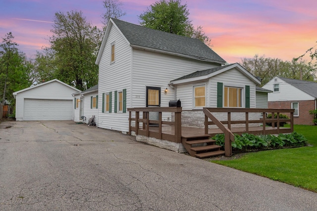 205 E Murphy St, Bay City, MI 48706 - view of front of house with a garage, an outdoor structure, a deck, a shingled roof, and a lawn