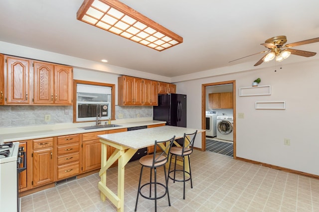 205 E Murphy St, Bay City, MI 48706 - kitchen with freestanding refrigerator, white gas range oven, a sink, light countertops, and recessed lighting