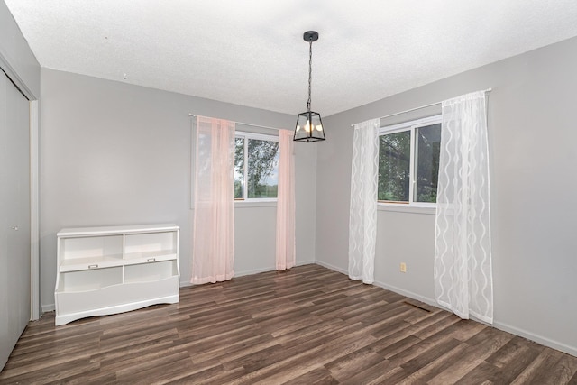 4719 Myra Lee Dr, Auburn, MI 48611 - unfurnished dining area with wood finished floors, a chandelier, baseboards, and a textured ceiling