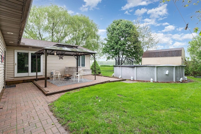 4719 Myra Lee Dr, Auburn, MI 48611 - view of green lawn with a gazebo, a wooden deck, an outdoor pool, and a fire pit