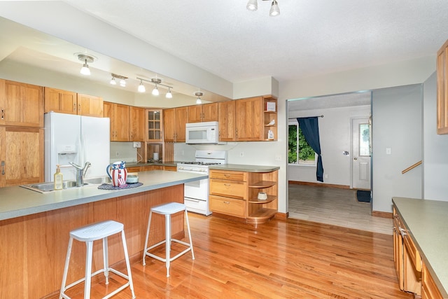 4719 Myra Lee Dr, Auburn, MI 48611 - kitchen with white appliances, open shelves, a sink, a breakfast bar, and glass insert cabinets