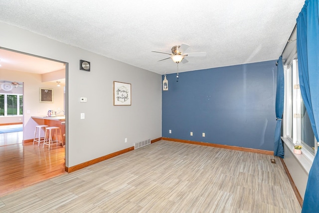 4719 Myra Lee Dr, Auburn, MI 48611 - spare room with ceiling fan, light wood finished floors, a textured ceiling, and baseboards