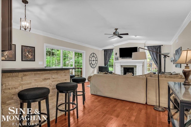 55266 Lordona Ln, Shelby Twp, MI 48315 - living room with a ceiling fan, wood finished floors, ornamental molding, a fireplace, and vaulted ceiling