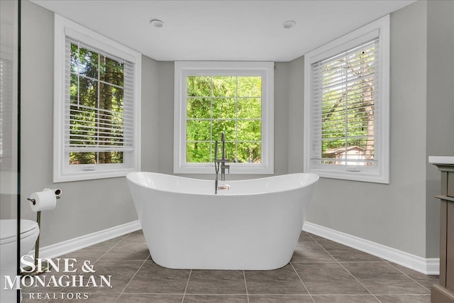 55266 Lordona Ln, Shelby Twp, MI 48315 - bathroom with a freestanding bath, tile patterned floors, baseboards, vanity, and toilet